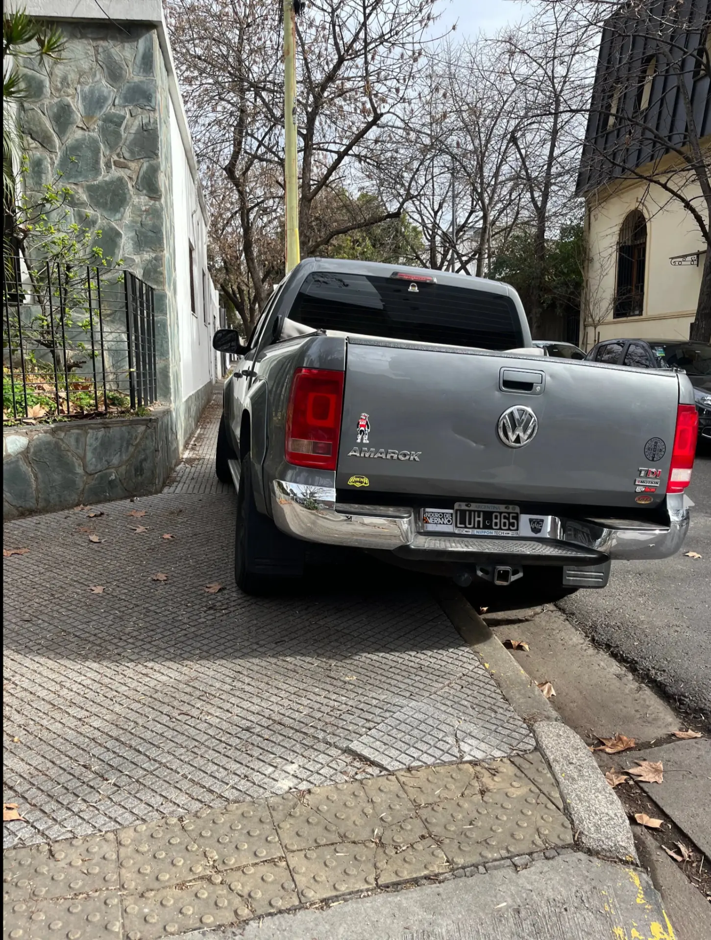 VW Amarok gris obstruyendo rampa de accesibilidad en la vereda.